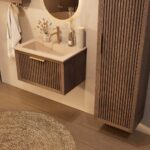 Het Riva badkamermeubel 70 in donker eiken ademt luxe en rust. Massief eiken met groevenfront, hoogwaardige softclose lades en een mat beige Mineraalsteen wastafel. De wastafel kan met of zonder kraangaten worden geleverd.