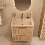 Het Riva badkamermeubel 70 in naturel eiken combineert ambachtelijk vakmanschap met moderne luxe. Gemaakt van massief eiken met ribbelfront, twee softclose lades en een mat beige Mineraalsteen wastafel. De wastafel kan met of zonder kraangaten worden