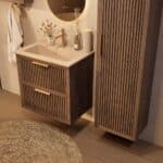 Het Riva badkamermeubel 70 in donker eiken ademt luxe en rust. Massief eiken met groevenfront, twee hoogwaardige softclose lades en een mat beige Mineraalsteen wastafel. De wastafel kan met of zonder kraangaten worden geleverd.