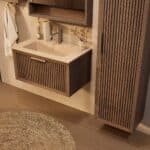 Het Riva badkamermeubel 80 in donker eiken ademt luxe en rust. Massief eiken met groevenfront, hoogwaardige softclose lades en een mat beige Mineraalsteen wastafel. De wastafel kan met of zonder kraangaten worden geleverd.