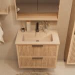 Het Riva badkamermeubel 80 in naturel eiken combineert ambachtelijk vakmanschap met moderne luxe. Gemaakt van massief eiken met ribbelfront, twee softclose lades en een mat beige Mineraalsteen wastafel. De wastafel kan met of zonder kraangaten worden