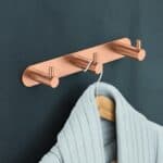 Strakke handdoekhaak met 3 haken uit de Grav serie, uitgevoerd in geborsteld koper met duurzame PVD-coating. Geschikt voor het ophangen van meerdere handdoeken of badjassen. Voor wandmontage. De afwerking sluit exact aan bij de geborsteld koperen PVD