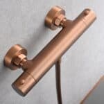 Thermostatische douchekraan in geborsteld koper met duurzame PVD-coating, geleverd als complete set met handdouche, doucheslang van 180 cm en wandhouder. Uit de Riva Bella serie, verkrijgbaar in 6 kleuren en geleverd met 5 jaar garantie.