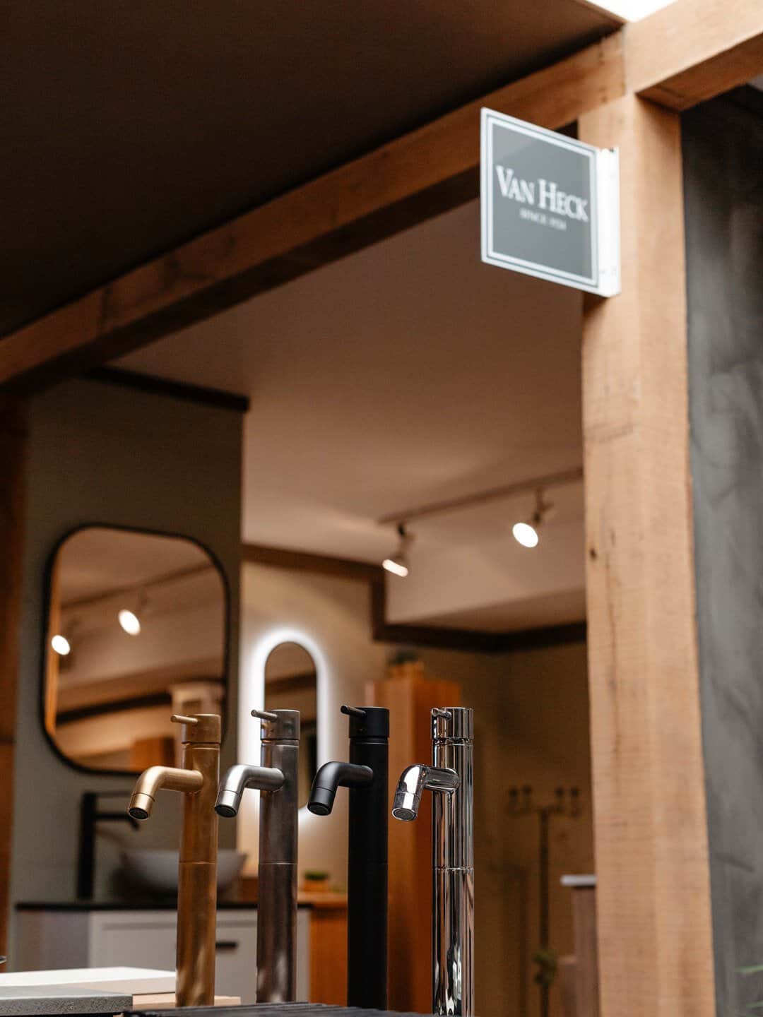 Doorkijk in de showroom met vrijstaande kranen en het Van Heck-bord