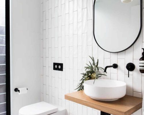 mooi industrieel badkamermeubel met witte waskom en zwarte spiegel