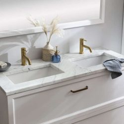 een klassiek badkamermeubel met twee ingebouwde waskommen en gouden kranen.