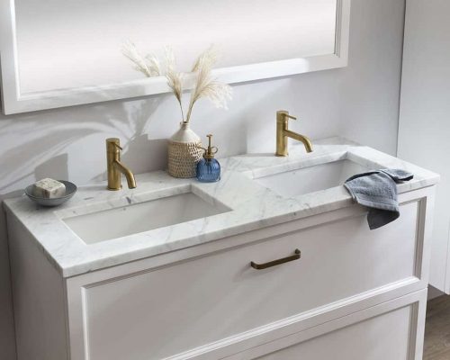 een klassiek badkamermeubel met twee ingebouwde waskommen en gouden kranen.