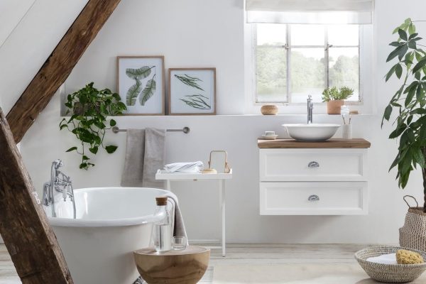 landelijke badkamer met eiken wastafelblad op het landelijke badmeubel met een vrijstaand bad op pootjes