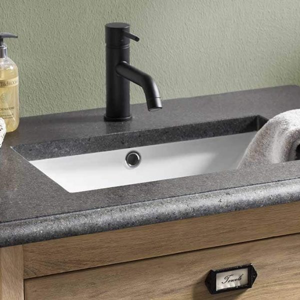 een houten badkamermeubel met een granieten wastafelblad en een zwarte kraan