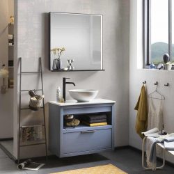 een blauw gespoten badkamermeubel met een keramische waskom, een spiegel en een zwarte kraan