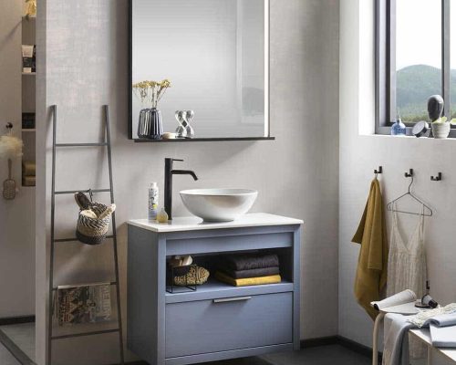 een blauw gespoten badkamermeubel met een keramische waskom, een spiegel en een zwarte kraan