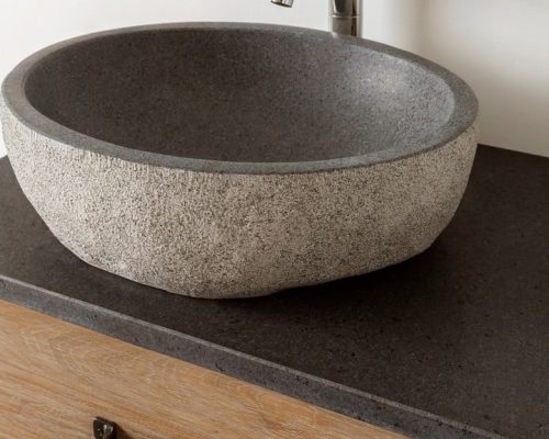 granieten waskom op een eiken meubel met mooie kraan